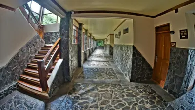 an empty hallway of a house with stone floors and stairs at El Establo Mountain Hotel in Monteverde Costa Rica