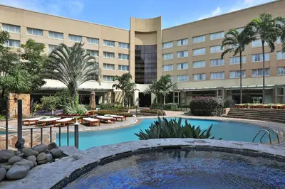 a hotel with a pool in front of a building at InterContinental Costa Rica at Multiplaza Mall by IHG in San José