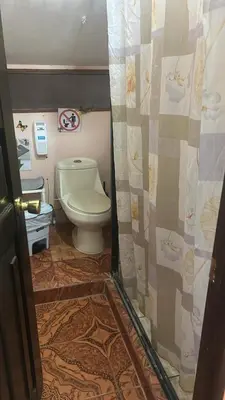 a bathroom with a toilet and a shower curtain at Nambí Rooms alojamiento no tradicional in Nambí