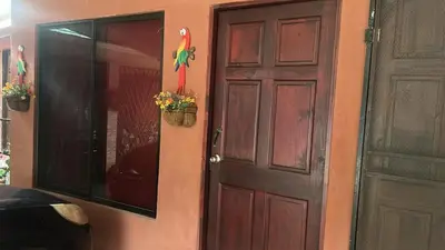 a door to a house with flowers in a window at Nambí Rooms alojamiento no tradicional in Nambí