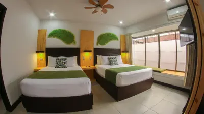 a hotel room with two beds and a window at Apartamentos Equipados RyA del Volcán in Fortuna