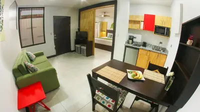 a living room with a green couch and a table at Apartamentos Equipados RyA del Volcán in Fortuna