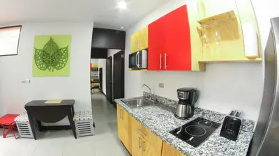 a kitchen with red and yellow cabinets and a sink at Apartamentos Equipados RyA del Volcán in Fortuna