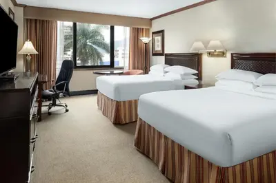 a hotel room with two beds and a desk at Delta Hotels by Marriott San Jose Aurola in San José