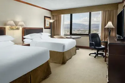 a hotel room with two beds and a desk at Delta Hotels by Marriott San Jose Aurola in San José