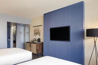 a bedroom with a blue wall with a tv on it at Hyatt Centric San José Escazú in San José
