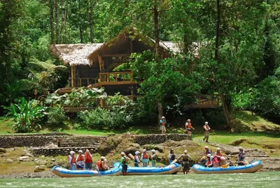 a group of people in canoes on a river at Pacuare Lodge by Böëna in Bajo Tigre