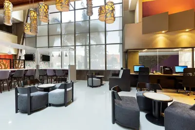 a restaurant with tables and chairs and a large window at Crowne Plaza San Jose La Sabana by IHG in San José