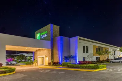 a mobil gas station at night with a car parked outside at Holiday Inn Express San Jose Costa Rica Airport by IHG in Alajuela City