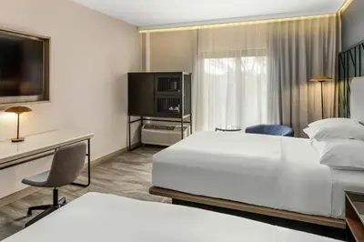 a hotel room with a bed and a flat screen tv at Courtyard by Marriott San Jose Escazu in San José
