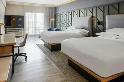 a hotel room with two beds and a desk at Courtyard by Marriott San Jose Escazu in San José