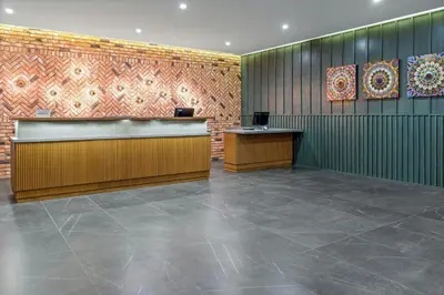 a lobby with a reception desk and paintings on the wall at Courtyard by Marriott San Jose Escazu in San José