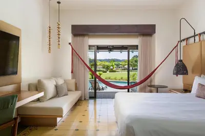 a hotel room with a bed and a hammock at Los Sueños Marriott Ocean & Golf Resort in Jacó