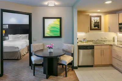 a hotel room with a bed and a kitchen with a table at Residence Inn by Marriott San Jose Escazu in San José