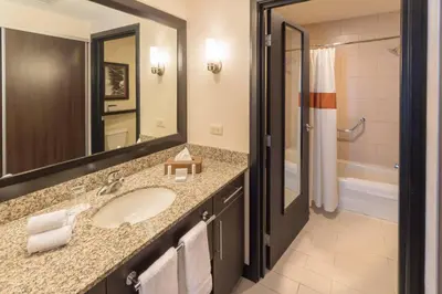 a bathroom with a sink and a mirror and a tub at Residence Inn by Marriott San Jose Escazu in San José