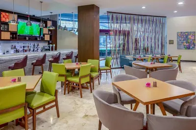 a restaurant with tables and chairs and a bar at Residence Inn by Marriott San Jose Escazu in San José
