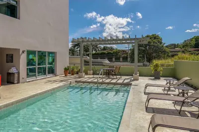 a swimming pool with chairs and a pergola at Residence Inn by Marriott San Jose Escazu in San José