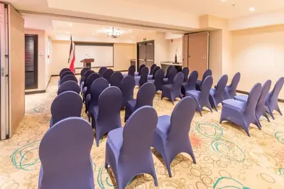 a conference room with blue chairs and a podium at Residence Inn by Marriott San Jose Escazu in San José