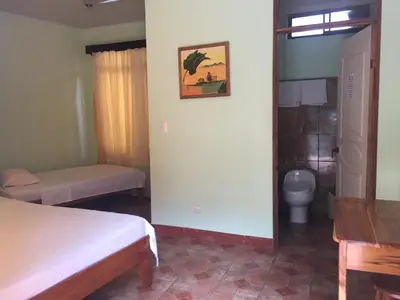 a bedroom with two beds and a toilet in it at Cabinas Brisas del Golfo in Colorado
