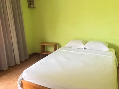 a bed in a room with a green wall at Cabinas Brisas del Golfo in Colorado