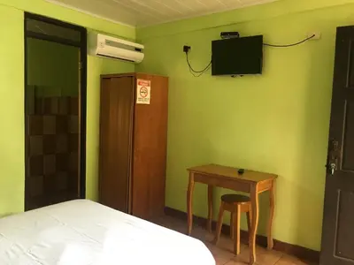 a bedroom with a bed and a table and a tv at Cabinas Brisas del Golfo in Colorado