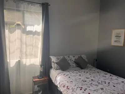 a bedroom with a bed and a window with a bedspread at Residencias Arenal in Fortuna
