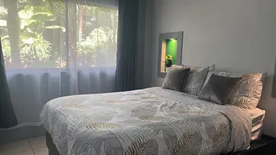 a bedroom with a large bed with a window at Residencias Arenal in Fortuna