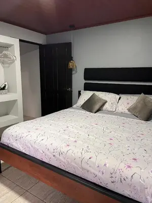 a bedroom with a bed with pink flowers on it at Residencias Arenal in Fortuna