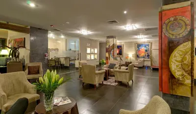 a lobby with chairs and tables and a waiting room at Studio Hotel Boutique in San José