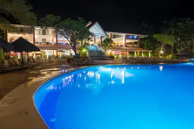 a swimming pool in front of a hotel at night at Occidental Tamarindo - All Inclusive in Tamarindo