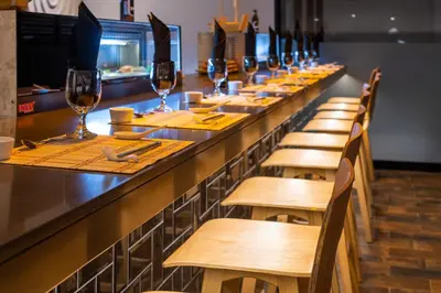 a long bar with wooden chairs and wine glasses at Occidental Tamarindo - All Inclusive in Tamarindo