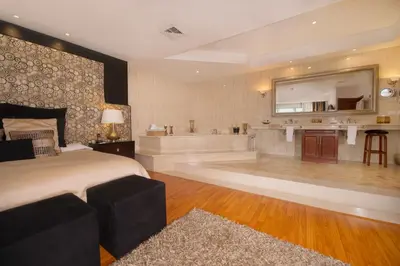 a bedroom with a tub and a bed and a bath room at Hotel Palma Real in San José