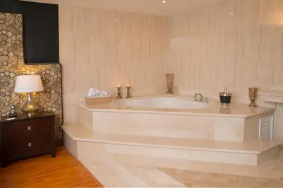 a large white bath tub in a room with a lamp at Hotel Palma Real in San José