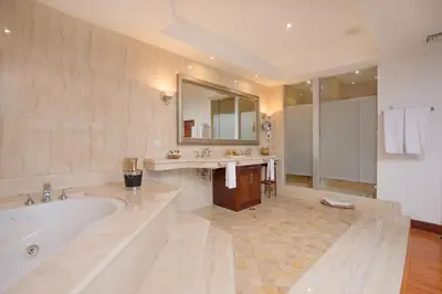 a large bathroom with a tub and a large mirror at Hotel Palma Real in San José