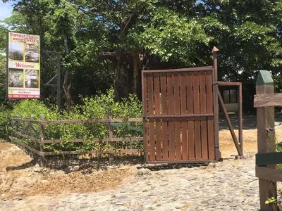 a wooden gate next to a wooden fence at Tiquisia Lodge in Curubandé