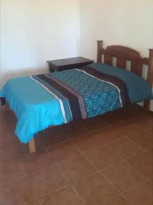 a bedroom with a bed with a blue blanket at Tiquisia Lodge in Curubandé