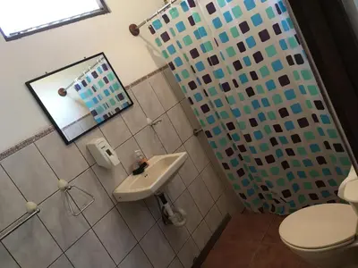 a bathroom with a toilet and a sink at Tiquisia Lodge in Curubandé