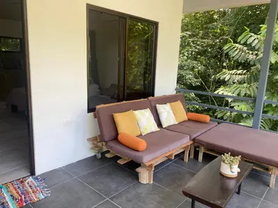 a couch sitting on the porch of a house at Villas en el Bosque in Ojochal