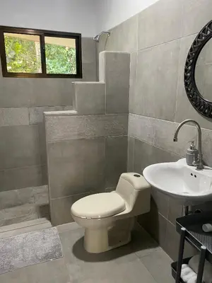 a bathroom with a toilet and a sink at Villas en el Bosque in Ojochal