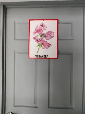 a sign on a door with a flower on it at Cabinas Maritza in Quebrada Ganado