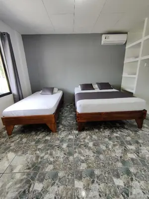 two beds sitting next to each other in a room at Cabinas Maritza in Quebrada Ganado