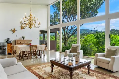 a living room with white furniture and large windows at Quinta Esencia in Alajuela City