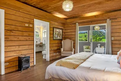 a bedroom with a bed and a wood paneled wall at Quinta Esencia in Alajuela City