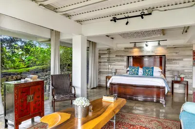 a bedroom with a bed and a wooden wall at Quinta Esencia in Alajuela City