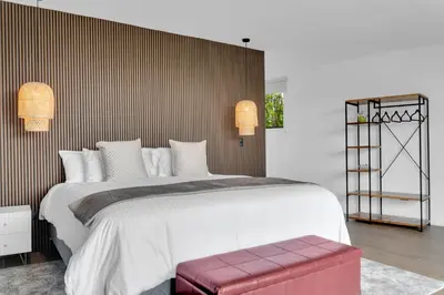 a bedroom with a large white bed with a red wall at Quinta Esencia in Alajuela City