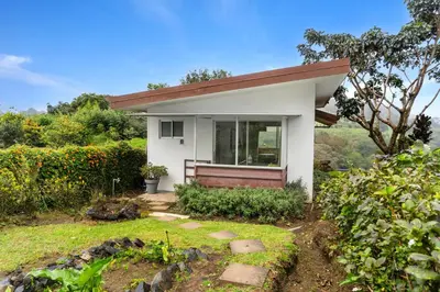 a small white house with a window in a yard at Quinta Esencia in Alajuela City