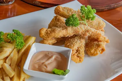 a plate of food with chicken tenders and french fries at Villas Fernanda in Fortuna