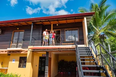 a family standing on the balcony of a house at Villas Fernanda in Fortuna