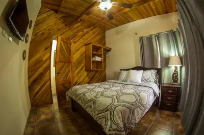 a bedroom with a bed and a wooden wall at Villas Fernanda #2 in Fortuna