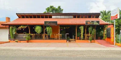 a restaurant with an orange building with tables at Villas Fernanda #2 in Fortuna